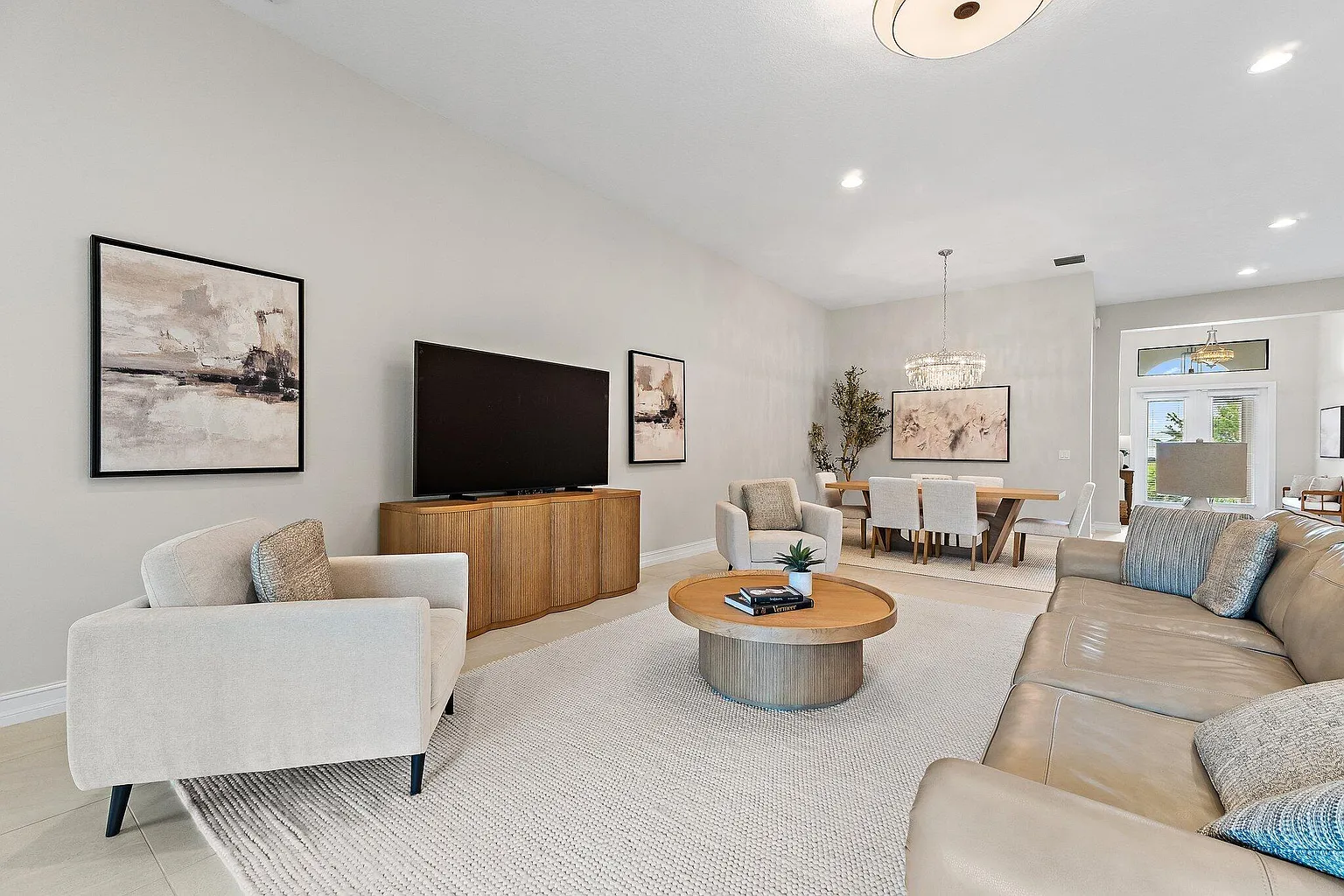 Open-plan living room with sofa, accent chairs, and adjoining dining area